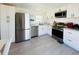 Bright kitchen boasts stainless steel appliances and white cabinets with modern hardware at 3414 Spanish Oak Ter, Sarasota, FL 34237