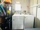 Utility room with modern washer and dryer, water heater, shelves and ample storage space at 3414 Spanish Oak Ter, Sarasota, FL 34237