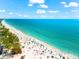 Stunning aerial view of a crowded beach with clear turquoise water and sunny skies at 3601 East Bay Dr # 205, Holmes Beach, FL 34217