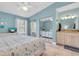 Comfortable bedroom featuring tiled floors, pale blue walls, and ensuite bath at 3601 East Bay Dr # 205, Holmes Beach, FL 34217
