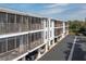 Condo building exterior with screened in porch overlooking parking and landscaping at 3601 East Bay Dr # 205, Holmes Beach, FL 34217