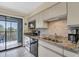 Kitchen with stainless steel appliances, granite countertops and balcony access at 3601 East Bay Dr # 205, Holmes Beach, FL 34217
