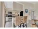 Modern kitchen with bar seating, neutral cabinets, stainless steel appliances, and granite countertops at 3601 East Bay Dr # 205, Holmes Beach, FL 34217