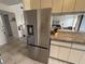 Modern stainless steel refrigerator with views to kitchen countertop, bar seating and living room at 3601 East Bay Dr # 205, Holmes Beach, FL 34217