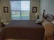 Bedroom includes a queen-sized bed, window with blinders, and a comfortable recliner at 3780 Pinebrook Cir # 102, Bradenton, FL 34209