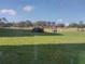 Scenic view of golf course featuring several carts driving on the lush green fairway and a view of the building at 3780 Pinebrook Cir # 102, Bradenton, FL 34209