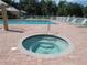 Relax in the community's hot tub, featuring a step-down design and situated next to a larger sparkling pool at 3780 Pinebrook Cir # 102, Bradenton, FL 34209