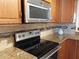 Well-equipped kitchen featuring a stainless steel microwave, smooth cooktop and granite countertops at 3780 Pinebrook Cir # 102, Bradenton, FL 34209
