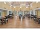 Spacious meeting room with vaulted ceilings, wood floors, natural light, tables and chairs for gatherings at 3780 Pinebrook Cir # 102, Bradenton, FL 34209