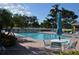 Enjoy the community's sparkling pool surrounded by lush landscaping, comfortable lounge chairs, and tables with umbrellas at 3780 Pinebrook Cir # 102, Bradenton, FL 34209