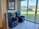 Cozy sunroom features reclining chairs and sliding glass doors to a lush landscape at 3780 Pinebrook Cir # 102, Bradenton, FL 34209