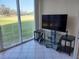 Bright sunroom with a scenic view, featuring a modern entertainment center at 3780 Pinebrook Cir # 102, Bradenton, FL 34209