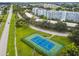 Aerial view of well-maintained tennis courts next to lush landscaping and condo buildings for recreational enjoyment at 3780 Pinebrook Cir # 102, Bradenton, FL 34209