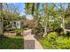 Lush backyard garden with brick paver walkway, mature trees, and vibrant plantings at 4109 Riverview Blvd, Bradenton, FL 34209