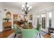 Dining area featuring a glass table, green chairs, and access to the kitchen with wood cabinets at 4109 Riverview Blvd, Bradenton, FL 34209