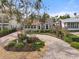 Charming stucco home featuring a brick driveway, manicured landscaping, and an inviting front porch at 4109 Riverview Blvd, Bradenton, FL 34209