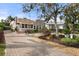 Charming stucco home featuring a brick driveway, manicured landscaping, and an inviting front porch at 4109 Riverview Blvd, Bradenton, FL 34209