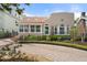 Charming stucco home featuring a brick driveway, manicured landscaping, and an inviting front porch at 4109 Riverview Blvd, Bradenton, FL 34209