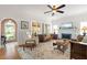 Bright living room featuring a fireplace, ceiling fan, hardwood floors, and ample natural light at 4109 Riverview Blvd, Bradenton, FL 34209