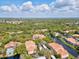 Aerial view showcasing the community's multiple buildings, lake, lush landscaping, and well maintained terracotta tile roofs at 4178 Central Sarasota Pkwy # 325, Sarasota, FL 34238