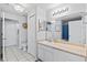 Bathroom with white cabinets, large mirror, and blue patterned shower curtain at 4178 Central Sarasota Pkwy # 325, Sarasota, FL 34238