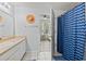 Bright bathroom with a vanity and a blue shower curtain at 4178 Central Sarasota Pkwy # 325, Sarasota, FL 34238