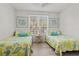 Bright bedroom with two twin beds, white walls, and a sunny window at 4178 Central Sarasota Pkwy # 325, Sarasota, FL 34238