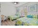 Coastal decorated bedroom with two twin beds, ceiling fan, and sunny window at 4178 Central Sarasota Pkwy # 325, Sarasota, FL 34238