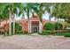 Exterior view of a community building, manicured landscaping, brick pavers and surrounding colorful foliage at 4178 Central Sarasota Pkwy # 325, Sarasota, FL 34238