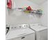 Laundry room featuring a white washer and dryer with a wire shelf overhead at 4178 Central Sarasota Pkwy # 325, Sarasota, FL 34238