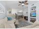 Bright open-concept living room with ceiling fan, modern furniture, and bar seating at the kitchen counter at 4178 Central Sarasota Pkwy # 325, Sarasota, FL 34238