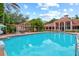 Beautiful community pool with an adjacent clubhouse and tropical landscaping around the area at 4178 Central Sarasota Pkwy # 325, Sarasota, FL 34238