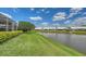 Scenic backyard featuring a tranquil pond view, manicured lawn, and lush landscaping at 4181 Brittany Ln # 25, Sarasota, FL 34233