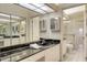 Bright bathroom featuring dual sinks with black granite countertops, tiled floors and a glass-enclosed shower at 4181 Brittany Ln # 25, Sarasota, FL 34233