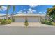 Two-car garage with a tile roof, nice landscaping, and a well maintained concrete driveway at 4181 Brittany Ln # 25, Sarasota, FL 34233