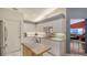 Well-lit kitchen features white cabinets, tiled countertops and backsplash, and flows to adjacent living area at 4181 Brittany Ln # 25, Sarasota, FL 34233
