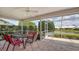 Screened-in lanai with table and chairs overlooks a serene lake and lush landscaping at 4181 Brittany Ln # 25, Sarasota, FL 34233