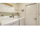 Well-lit laundry room with front-load washer and dryer, white cabinets, and convenient shelving at 4181 Brittany Ln # 25, Sarasota, FL 34233