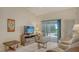 Inviting living room with tile floors, a ceiling fan, and a large sliding glass door leading to the lanai at 4181 Brittany Ln # 25, Sarasota, FL 34233