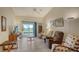 Spacious living room with tile flooring, ceiling fan, and access to screened-in patio with lake view at 4181 Brittany Ln # 25, Sarasota, FL 34233