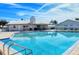 Community pool area with a sparkling pool, ample seating, and a well-maintained pool house under a bright, sunny sky at 4181 Brittany Ln # 25, Sarasota, FL 34233