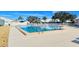 An outdoor pool is surrounded by lounge chairs and fencing, with lush trees nearby at 4181 Brittany Ln # 25, Sarasota, FL 34233