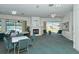 Bright recreation room with a cozy fireplace, tables, and views of the outdoor pool at 4181 Brittany Ln # 25, Sarasota, FL 34233