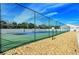 Outdoor tennis court with green fencing, well-maintained surface, under a clear blue sky in a sunny area at 4181 Brittany Ln # 25, Sarasota, FL 34233