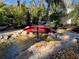 Zen backyard complete with a red footbridge, a koi pond, and a fountain at 4408 Midnight Pass Rd, Sarasota, FL 34242