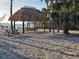 Enjoy beachside living with shaded picnic areas and tranquil ocean views under a tiki hut at 4408 Midnight Pass Rd, Sarasota, FL 34242