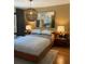Cozy bedroom with a modern light fixture and a unique piece of wall art at 4408 Midnight Pass Rd, Sarasota, FL 34242