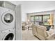 Open living area featuring a stacked washer/dryer and a sliding door to an outdoor patio at 4632 Ringwood Mdw # 28, Sarasota, FL 34235