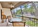Relaxing screened patio with a table and chairs, overlooking a lush green space and community pool at 4632 Ringwood Mdw # 28, Sarasota, FL 34235