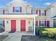 Inviting townhome exterior with red shutters, covered porch, and well-maintained landscaping creates a charming curb appeal at 4850 51St W St # 4205, Bradenton, FL 34210